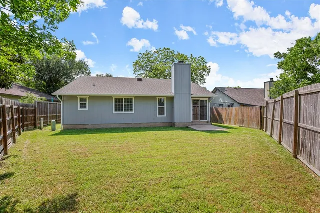 a backyard of a house with wooden floor and fence