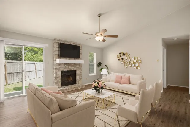 a living room with furniture a flat screen tv and a fireplace