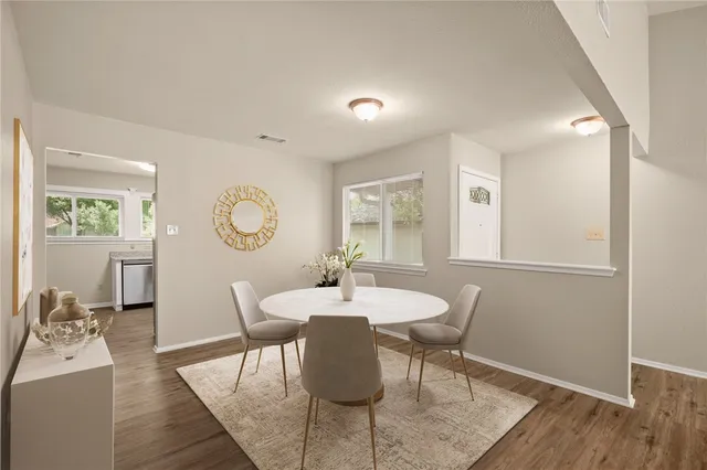 a dining room with wooden floor a glass table and chairs