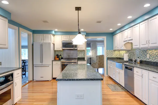 a kitchen with stainless steel appliances granite countertop a sink refrigerator and cabinets