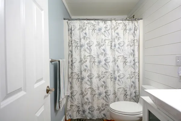 a bathroom with a toilet and a shower curtain