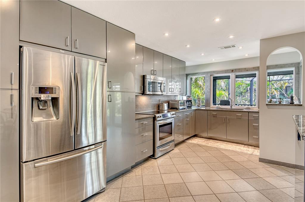 3210 Bayou Sound Longboat Key, FL 34228 - Photo 11 of 58 a kitchen with granite countertop a refrigerator and a sink