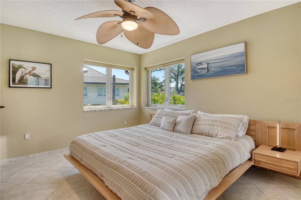 3210 Bayou Sound Longboat Key, FL 34228 - Photo 18 of 58 a bedroom with a large bed and a chandelier