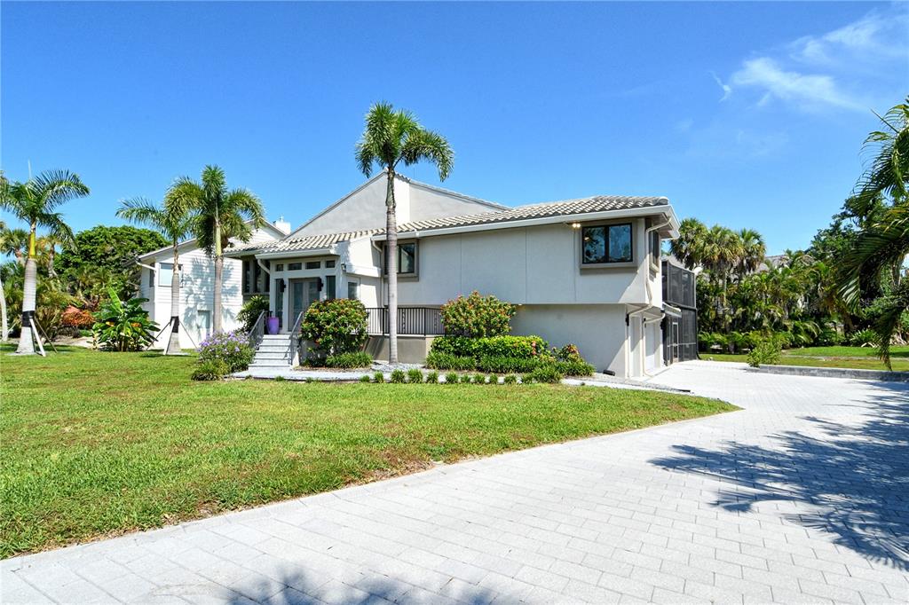 3210 Bayou Sound Longboat Key, FL 34228 - Photo 3 of 58 a front view of a house with a yard and potted plants