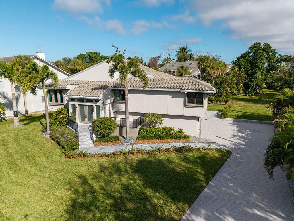 3210 Bayou Sound Longboat Key, FL 34228 - Photo 56 of 58 a view of a house with a big yard potted plants and large tree