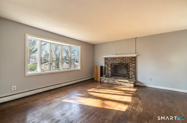 an empty room with fireplace and windows