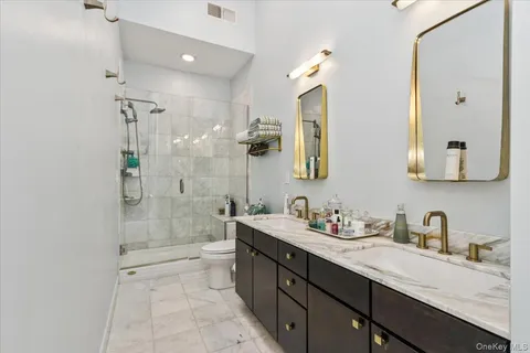 a bathroom with a double vanity sink mirror and shower