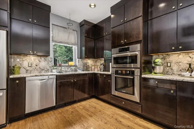 a kitchen with stainless steel appliances kitchen island granite countertop a stove a sink and a refrigerator