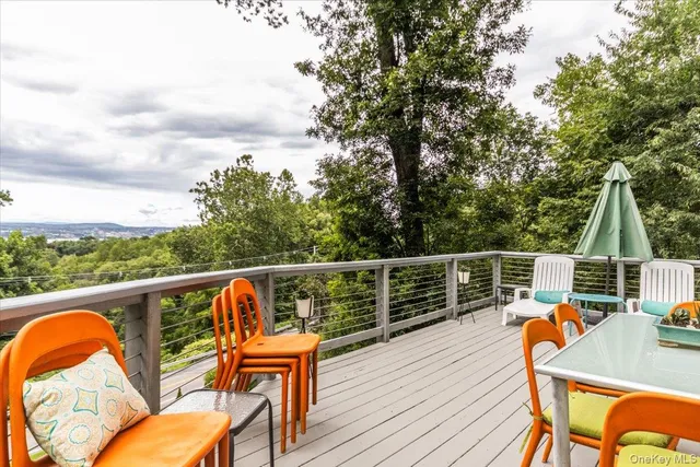 a balcony with wooden floor table and chairs