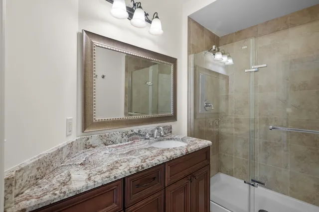 a bathroom with a granite countertop sink and a mirror
