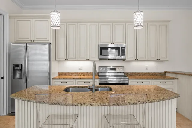 a kitchen with stainless steel appliances granite countertop a sink a stove and a refrigerator