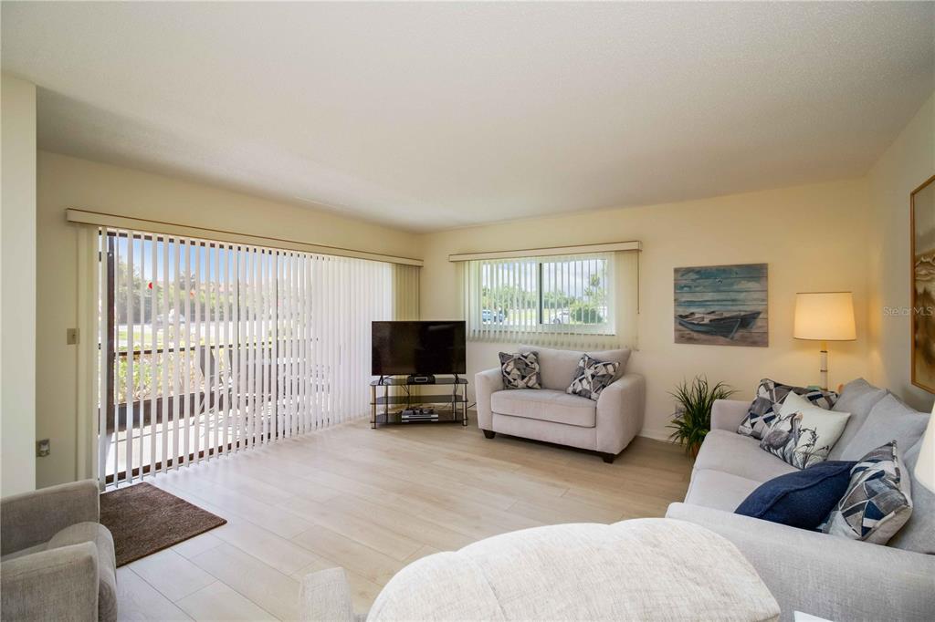 5476 Swift Road, Unit 19 Sarasota, FL 34231 - Photo 8 of 34 a living room with furniture a flat screen tv and a window