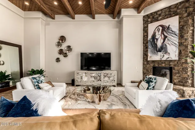 a bedroom with a bed a flat screen tv and a fireplace