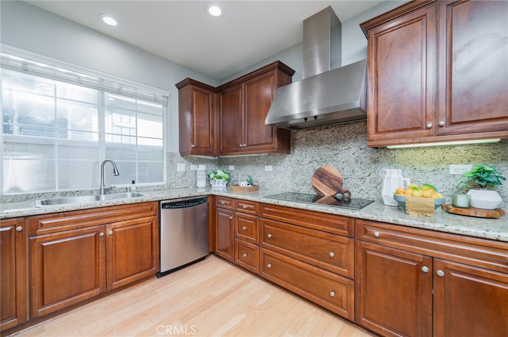 54 Shadowplay Irvine, CA 92620 - Photo 15 of 35 a kitchen with granite countertop wooden cabinets stainless steel appliances a sink and a window