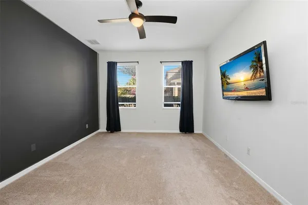 an empty room with windows and fan