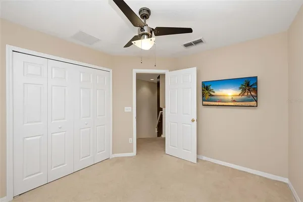 an empty room with closet and a ceiling fan