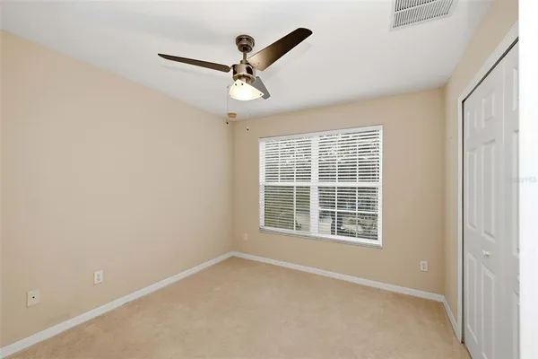 an empty room with a window and a fan