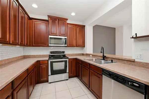 a kitchen with stainless steel appliances granite countertop a sink stove and microwave