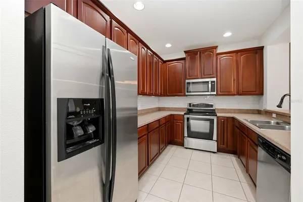 a kitchen with stainless steel appliances granite countertop a refrigerator and a stove top oven