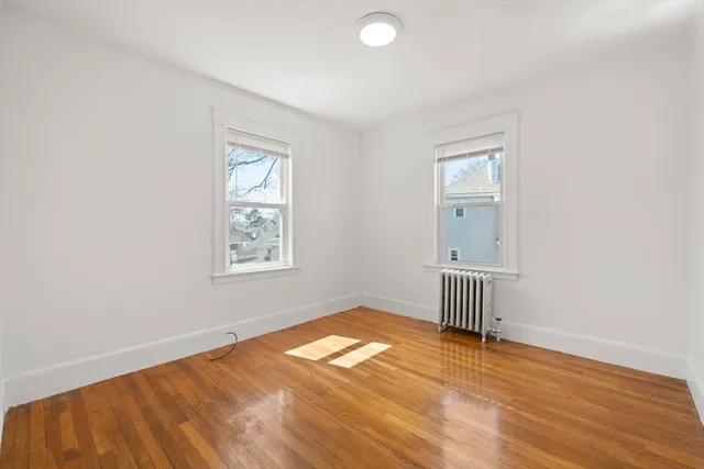 an empty room with a window and wooden floor