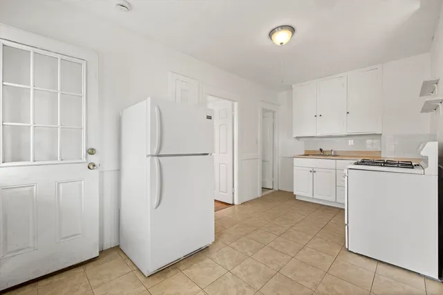 a kitchen with white cabinets and white appliances