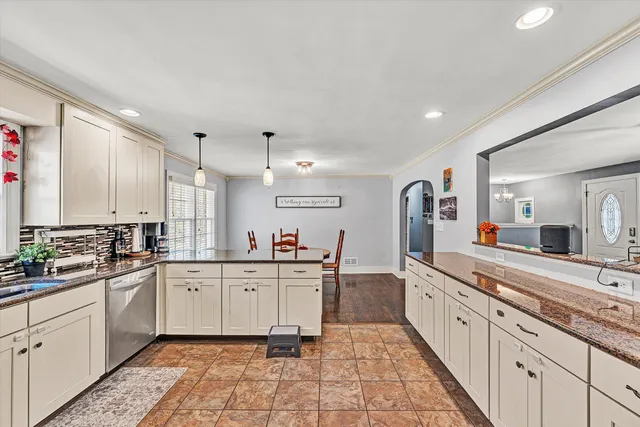 a kitchen with stainless steel appliances granite countertop a sink and a white cabinets