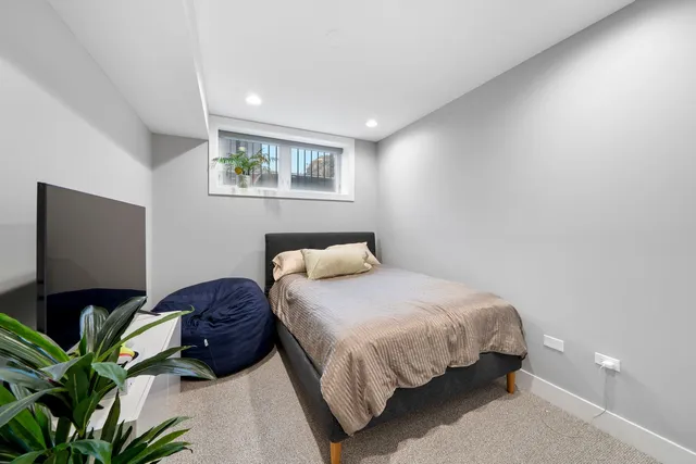 a bedroom with bed and a potted plant