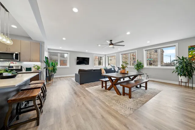 a living room with furniture kitchen view and a wooden floor