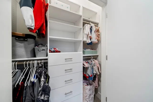a view of walk in closet with clothes and shoes