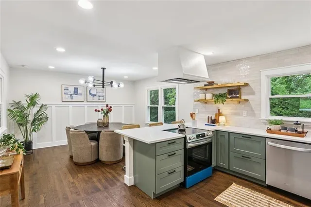 a kitchen that has a lot of cabinets in it and wooden floor