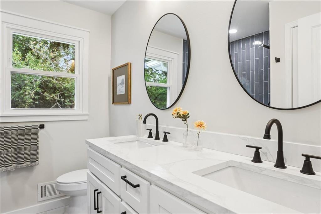 2152 Edgemore Drive Southeast Atlanta, GA 30316 - Photo 16 of 33 a bathroom with a toilet a sink a mirror and a window
