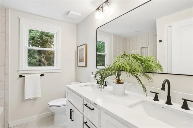a bathroom with a granite countertop sink and a large mirror