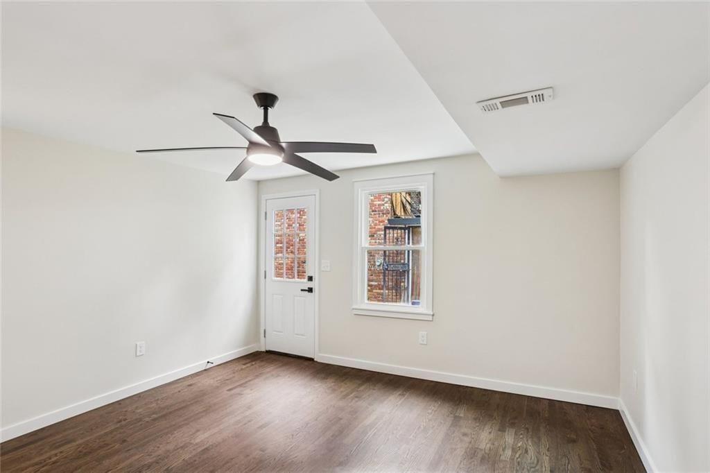 2152 Edgemore Drive Southeast Atlanta, GA 30316 - Photo 24 of 33 an empty room with wooden floor ceiling fan and windows