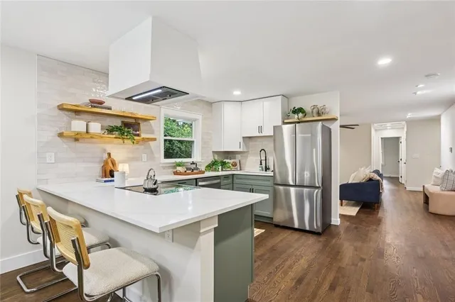a kitchen with refrigerator and wooden floor