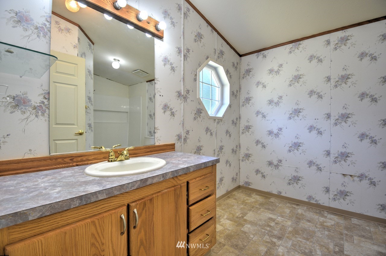 17327 Sargent Road Southwest Rochester, WA 98579 - Photo 11 of 23 a bathroom with a granite countertop sink a mirror and a shower