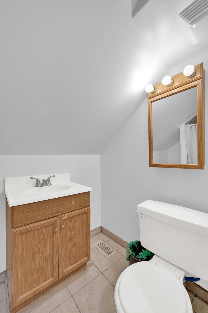 3826 South Honore Street Chicago, IL 60609 - Photo 14 of 19 a bathroom with a toilet a sink and mirror