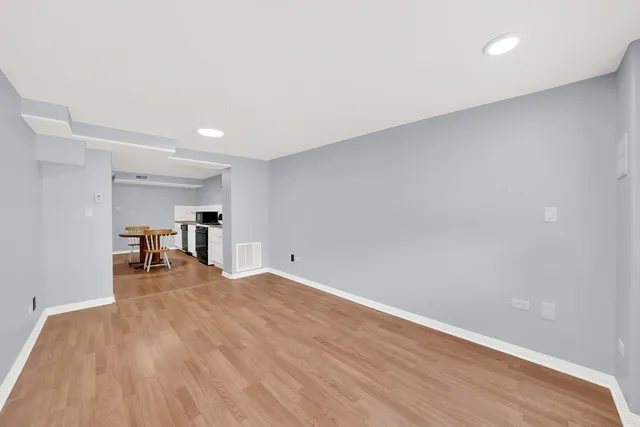 a view of empty room with wooden floor