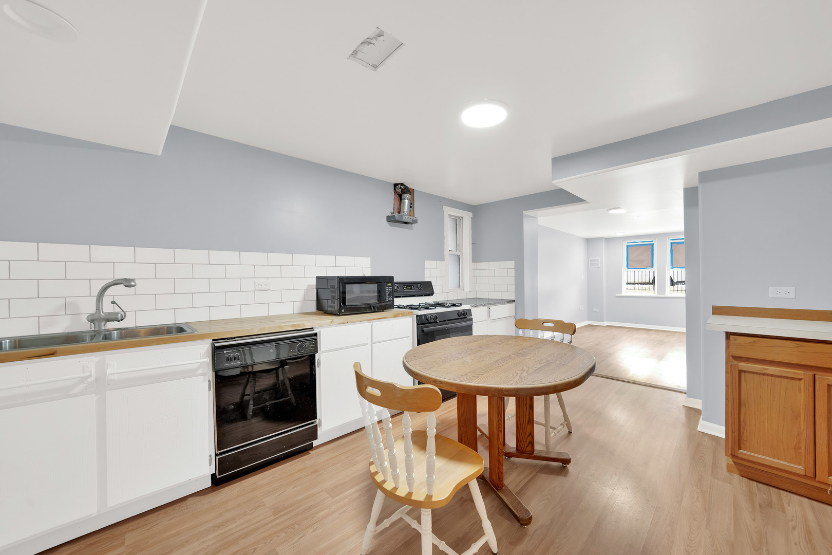 3826 South Honore Street Chicago, IL 60609 - Photo 7 of 19 a kitchen with stainless steel appliances granite countertop a kitchen island hardwood floor sink stove dining table and chairs