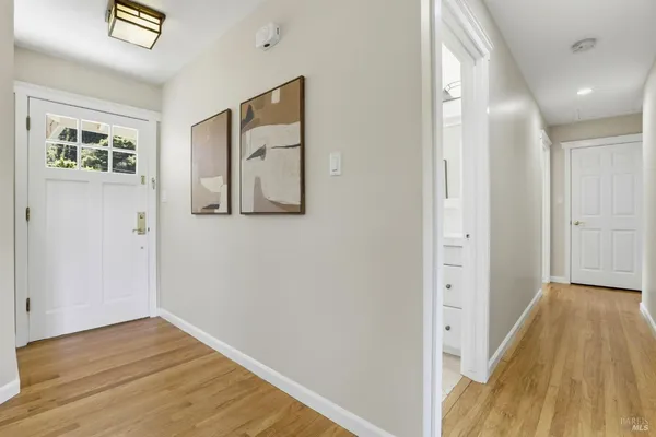 a view of a hallway with wooden floor and staircase