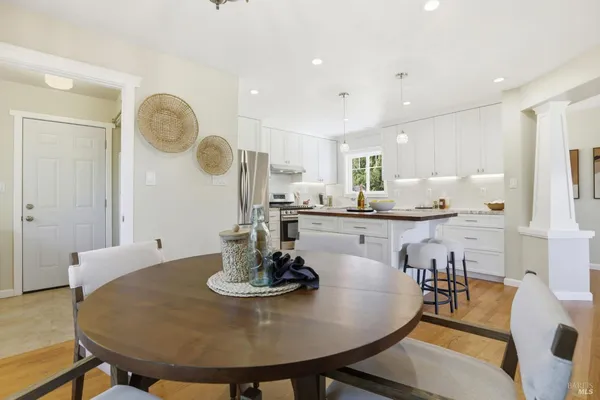 a dining room with wooden floor a glass table and chairs