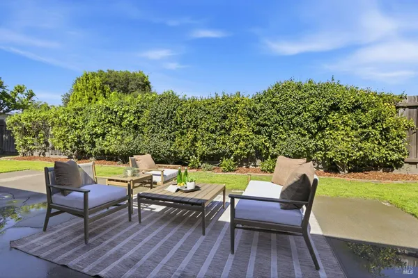 a backyard of a house with table and chairs