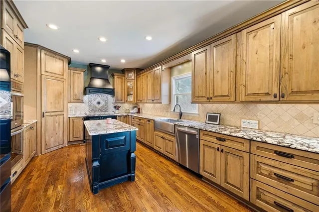 a view of staircase with lots of frames on wall and wooden floor