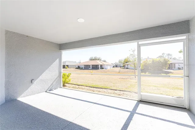 a view of an empty room with wooden floor and a large window