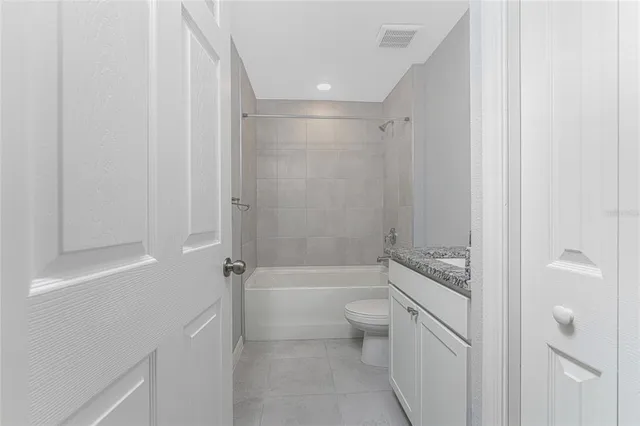 a bathroom with a granite countertop sink a toilet and shower