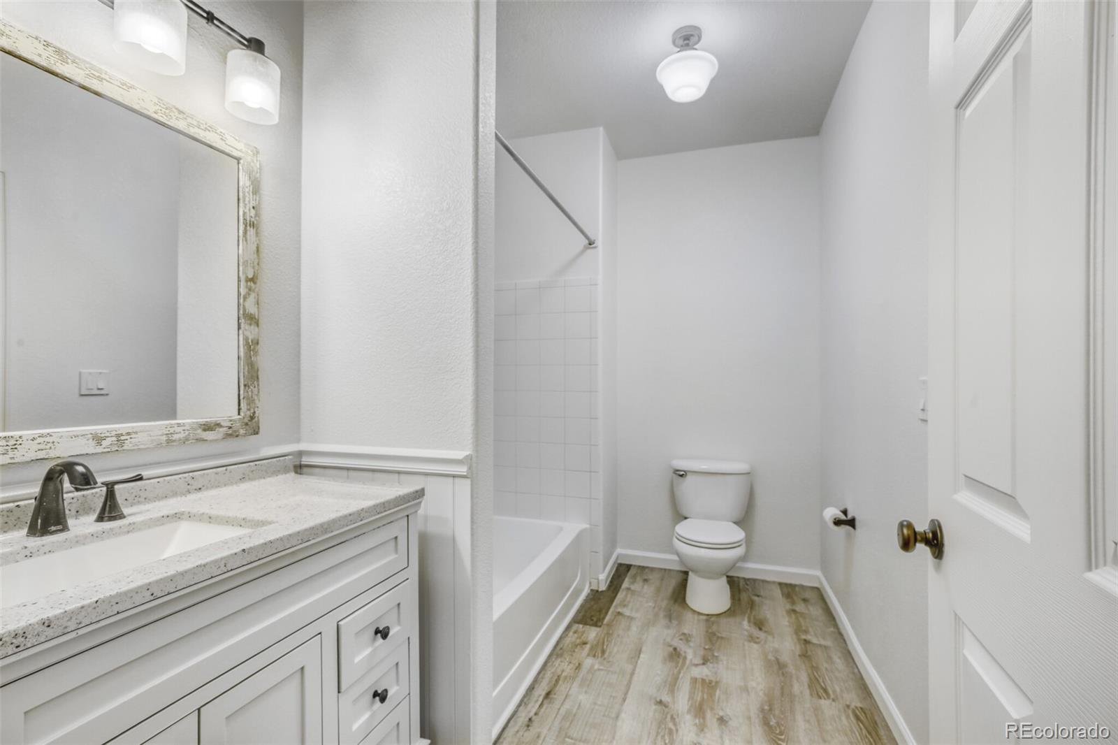 5255 Memphis Street, Unit 207 Denver, CO 80239 - Photo 18 of 21 a bathroom with a sink a toilet and a large mirror