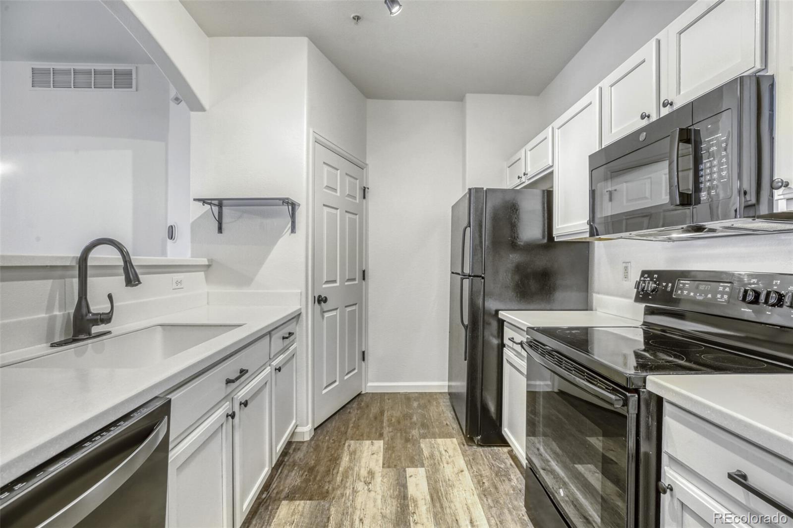 5255 Memphis Street, Unit 207 Denver, CO 80239 - Photo 4 of 21 a kitchen with stainless steel appliances granite countertop a sink stove and refrigerator