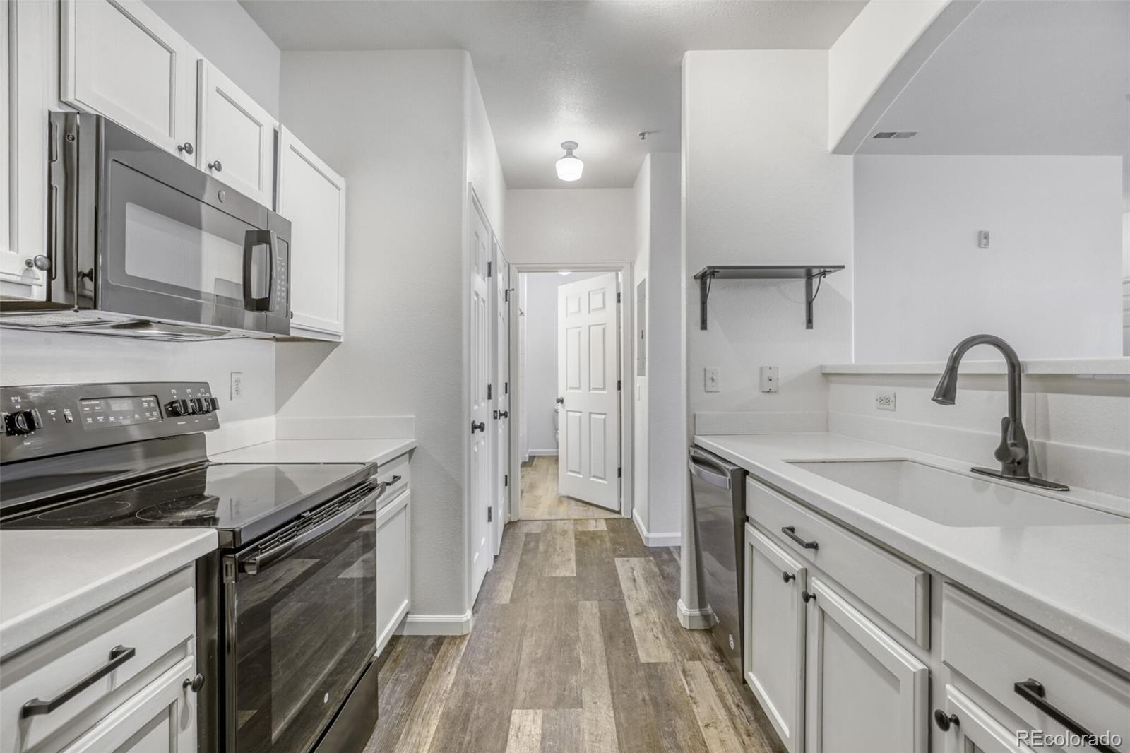 5255 Memphis Street, Unit 207 Denver, CO 80239 - Photo 6 of 21 a kitchen with a sink stove and refrigerator