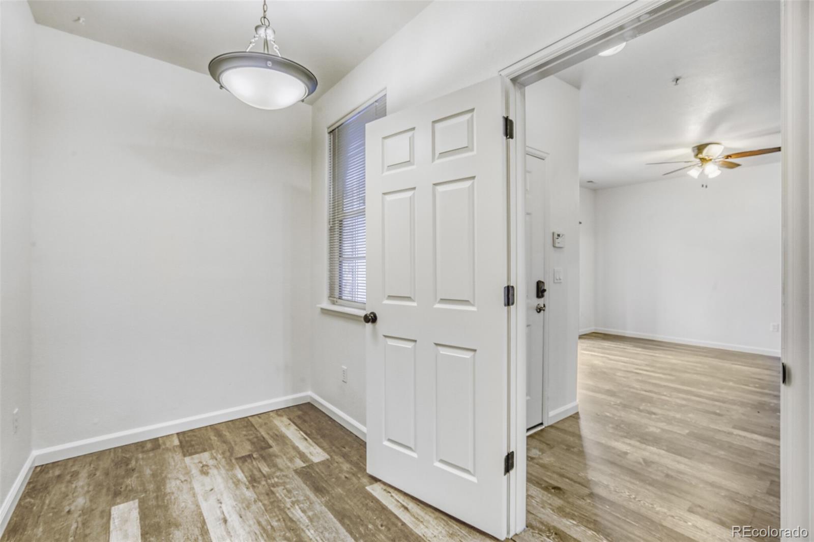 5255 Memphis Street, Unit 207 Denver, CO 80239 - Photo 8 of 21 a view of a hallway with wooden floor and chandelier