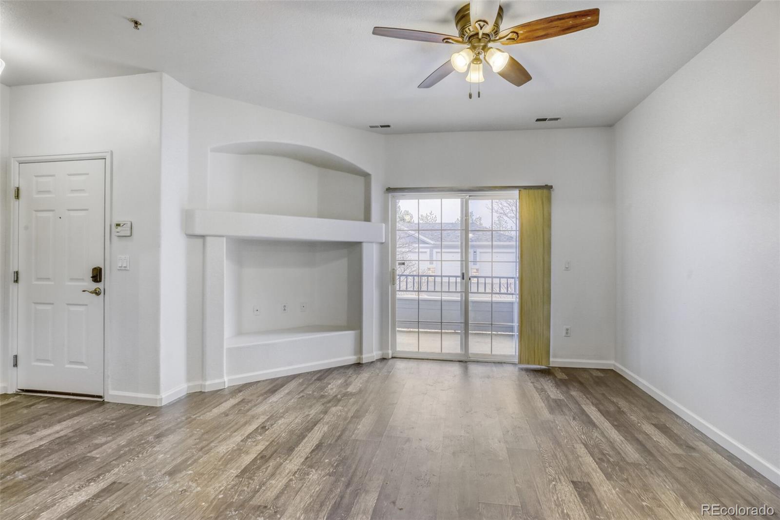 5255 Memphis Street, Unit 207 Denver, CO 80239 - Photo 10 of 21 an empty room with windows and chandelier fan