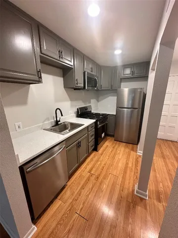 a kitchen with stainless steel appliances granite countertop a sink stove and refrigerator